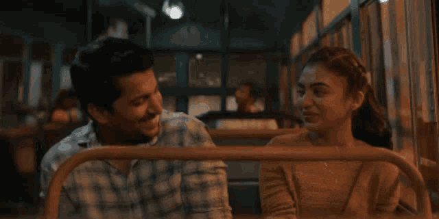 a man and a woman are looking at each other in a bus