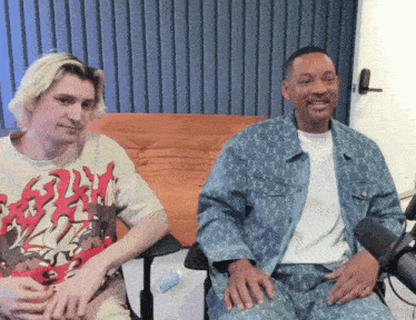 two men sitting next to each other with one wearing a t-shirt that says ' will smith ' on the front