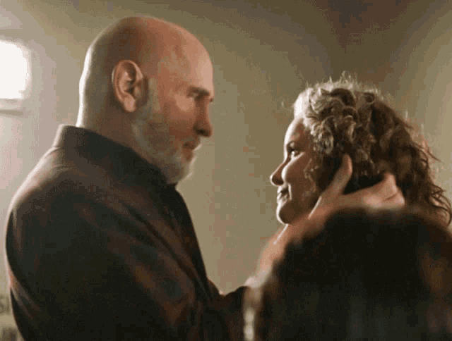 a man and a woman are touching each other 's foreheads