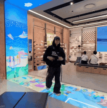 a man in a black hoodie is dancing in front of a sign that says mary jane