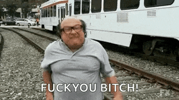 a man is standing on train tracks in front of a train and says `` fuck you bitch '' .