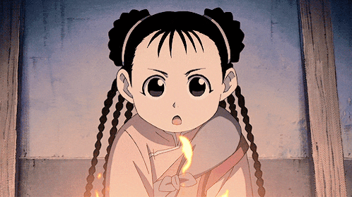 a little girl with braided hair is holding a fire in her hand