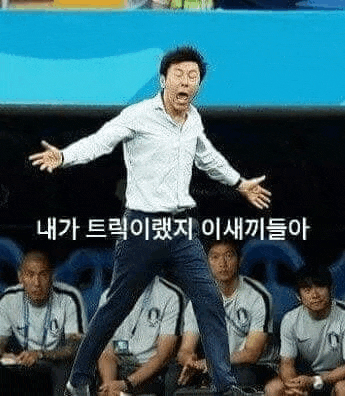 a man in a white shirt and blue pants is standing in front of a group of men .