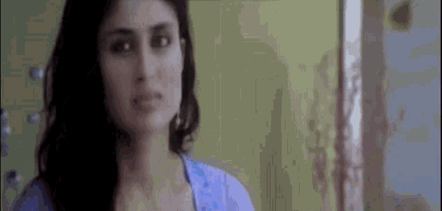 a close up of a woman 's face in a room with a yellow wall .