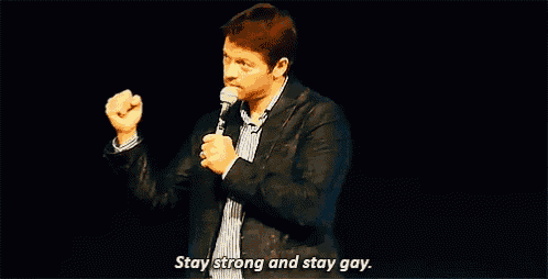 a man is holding a microphone and saying `` stay strong and stay gay '' while standing on a stage .