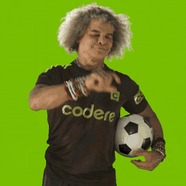a man with curly hair is holding a soccer ball and wearing a shirt that says te levo aqui