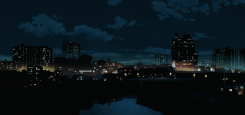 a cityscape at night with a river and buildings lit up