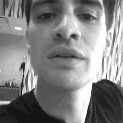 a close up of a man 's face in a black and white photo with his mouth open .