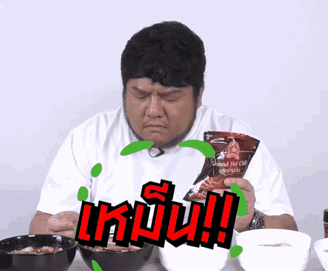 a man in a white shirt is holding a bag that says ground hot chili