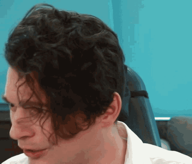a close up of a man 's face with curly hair