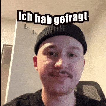 a man with a mustache is wearing a black beanie and has the words ich hab gefragt above him
