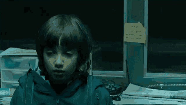 a little girl sitting in front of a window with a sticky note on the wall that says always