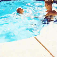 two people are swimming in a pool and one is looking at the camera