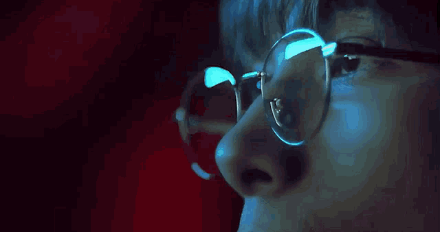 a close up of a person wearing round glasses