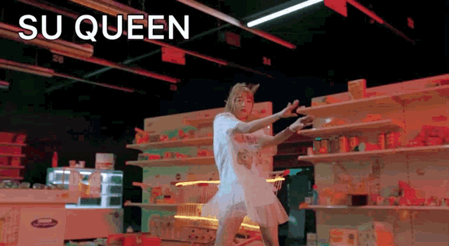 a woman in a white dress is dancing in a store with the words su queen written above her