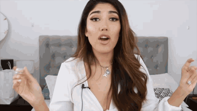 a woman wearing a white shirt and a necklace with a skull on it