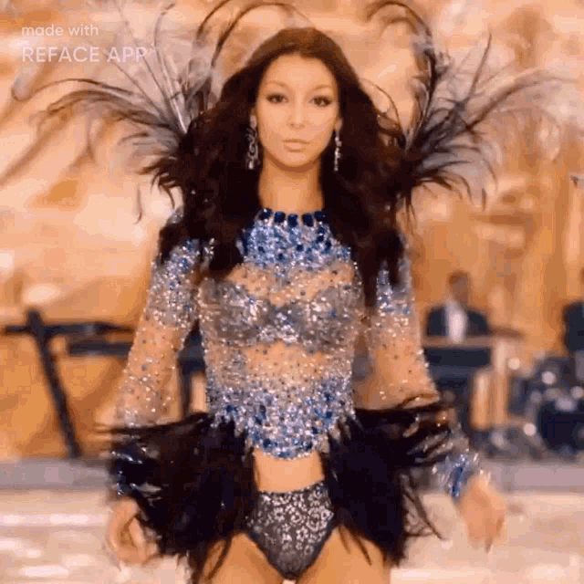 a woman is walking down a runway at a victoria 's secret fashion show wearing a blue and silver outfit .