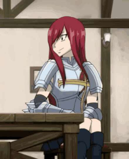 a girl with red hair is sitting at a table