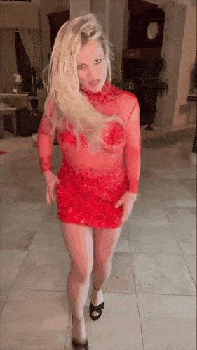 a woman in a red dress is dancing on a tiled floor