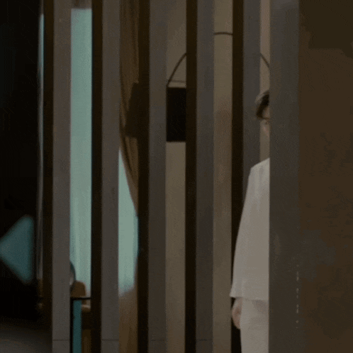 a man in a white shirt is standing in a room