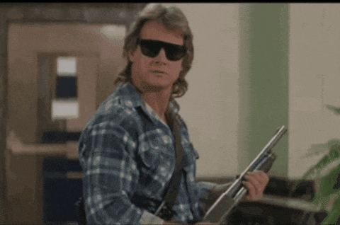 a man in a plaid shirt is holding a shotgun