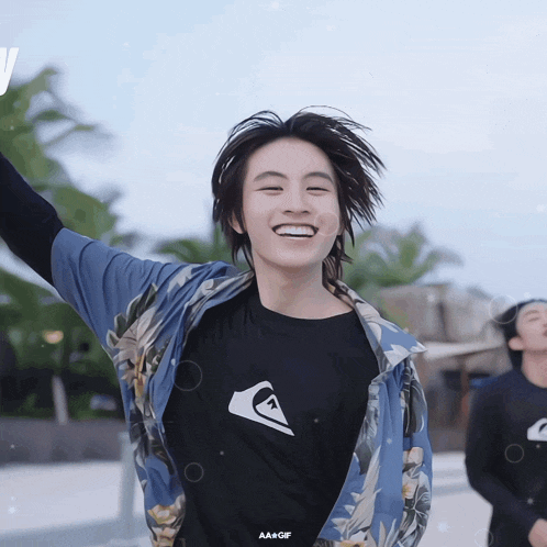 a man wearing a quiksilver shirt is smiling