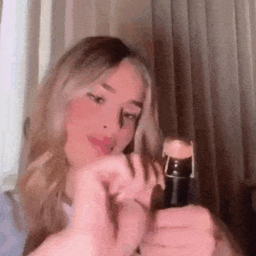 a woman is opening a bottle of champagne with a corkscrew .