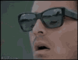 a close up of a person wearing sunglasses with a reflection of a man 's face .