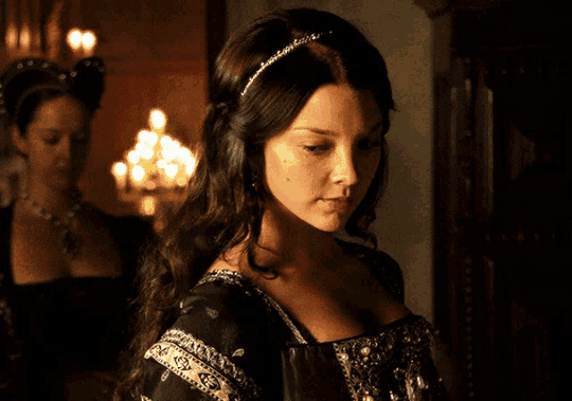 a woman in a black dress has a headband on her hair