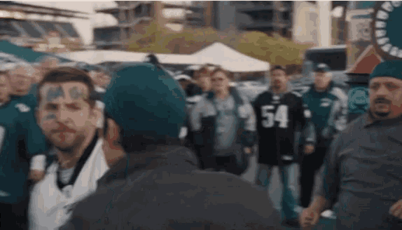 a man with the number 54 on his shirt stands in a crowd of people