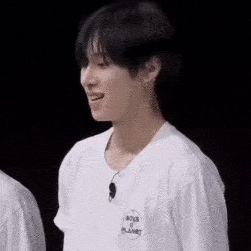 a man wearing a white shirt that says boys planet