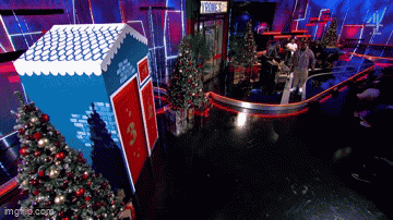 a group of people are standing in front of a christmas tree and a sign that says ' hollywood '