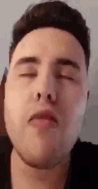 a man with his eyes closed is wearing a nose ring .