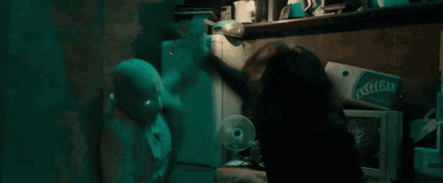 a man in a mask is standing in a dark room with a fan in his hand .