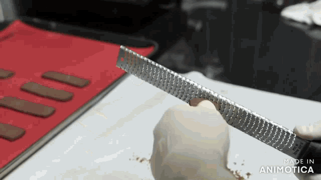 a person is grating something with a grater and the words made in animatica are on the bottom