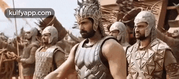 a group of men in armor are standing next to each other in a line .