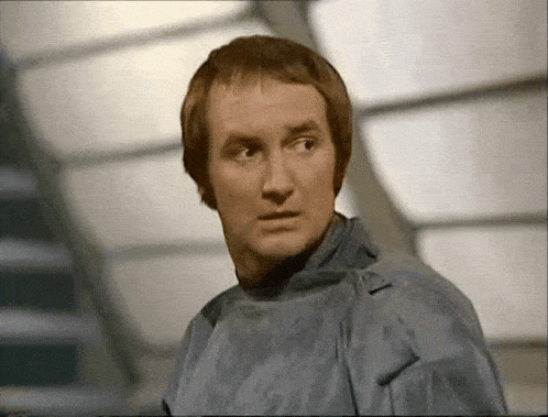 a man wearing a surgical gown looks at the camera