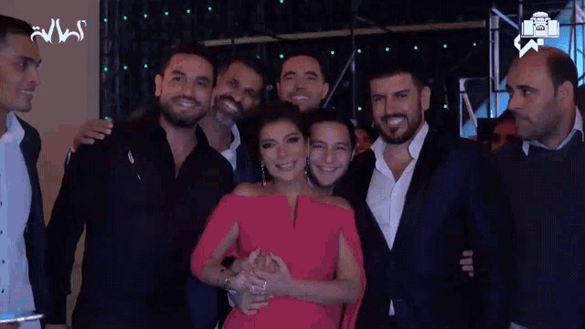 a woman in a red dress is surrounded by a group of men in suits and white shirts