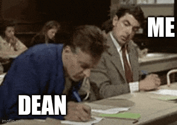 a man in a suit and tie is writing on a piece of paper while another man looks on .