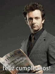 a man in a suit and tie is holding a newspaper with the words `` feliz cumpleanos '' written on it .