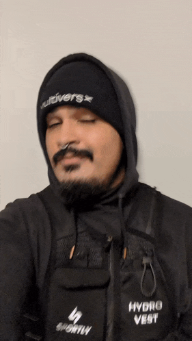 a man wearing a black hydro vest and a black beanie