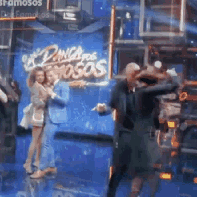 a group of people are dancing in front of a sign that says ' famosos '