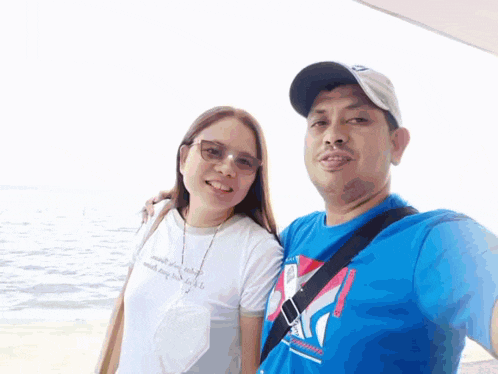 a man and a woman are posing for a picture and the woman is wearing a shirt that says ' a ' on it