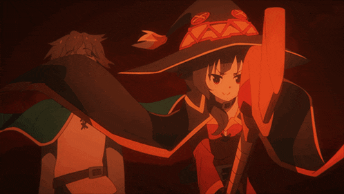 a man and a woman are standing next to each other and the woman is wearing a red witch hat