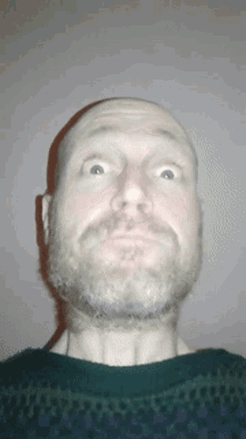 a man with a beard is making a funny face with his eyes closed