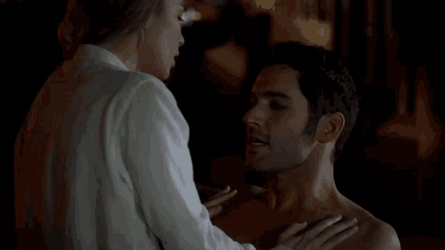 a shirtless man and a shirtless woman are looking at each other