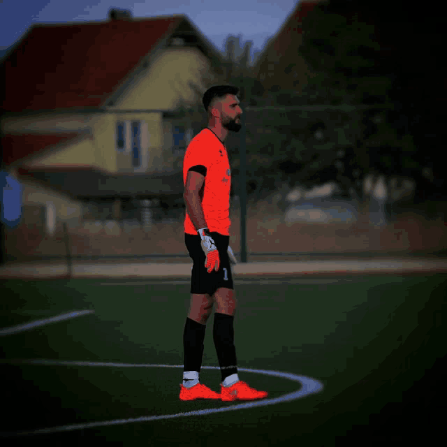 a soccer player with the number 1 on his shorts is standing on a field