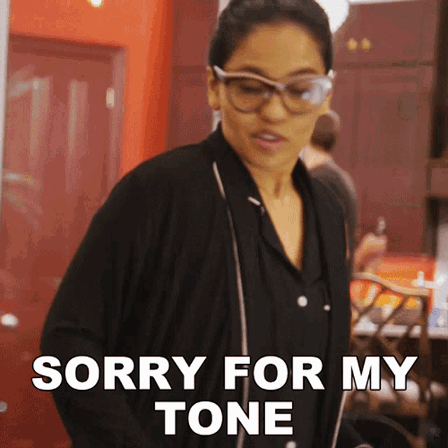 a woman wearing glasses and a black shirt says sorry for my tone