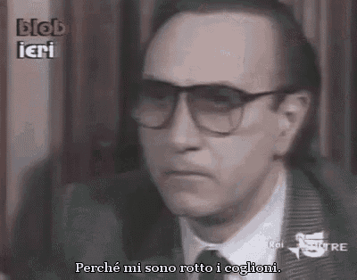 a man wearing glasses and a suit is talking to another man in a video .