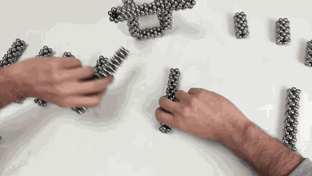 a person is playing with magnetic balls on a table
